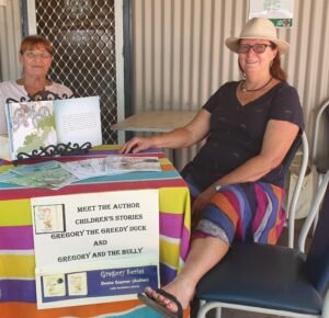 Person sitting at table at the markets selling books