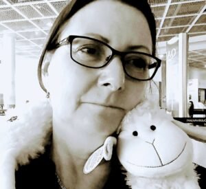 Person with stuff lamb around neck